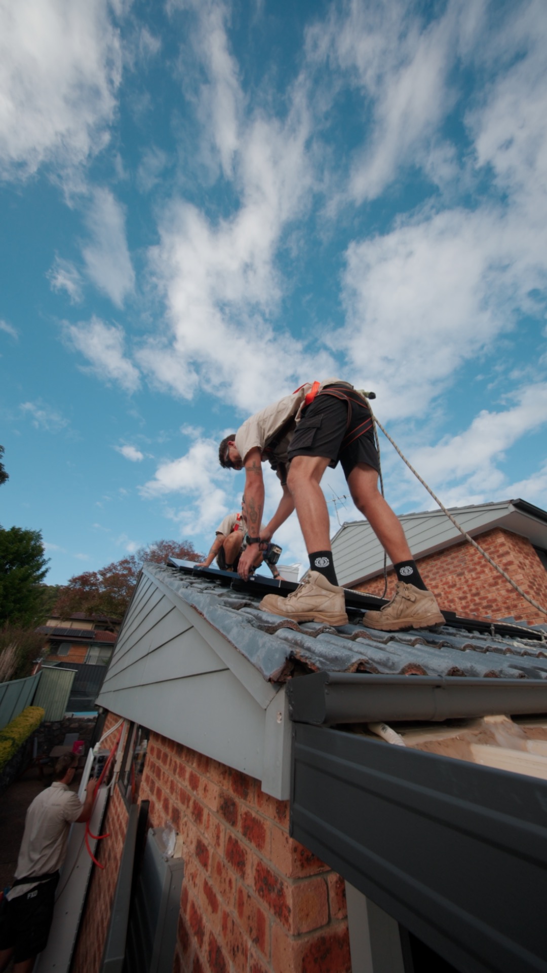 Elite Energy installer fitting a solar panel against a blue sky